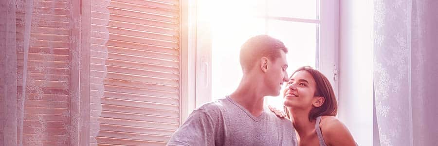 couple-in-love-staring-longingly-into-each-others-eyes-during-sunset-while-indoors